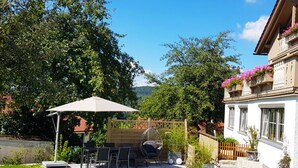 A patio with outdoor furniture, a pergola, and a view of a forested area. - Haus Leutner Bodenmais (Bodenmais)