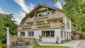 A two-story building with balconies, a patio with outdoor furniture, and a well-maintained garden. - Haus Leutner Bodenmais (Bodenmais)