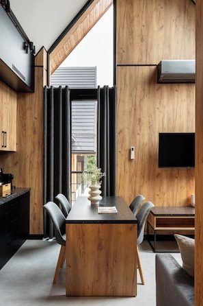 Una cocina moderna con una mesa de madera, sillas y una estufa integrada.
