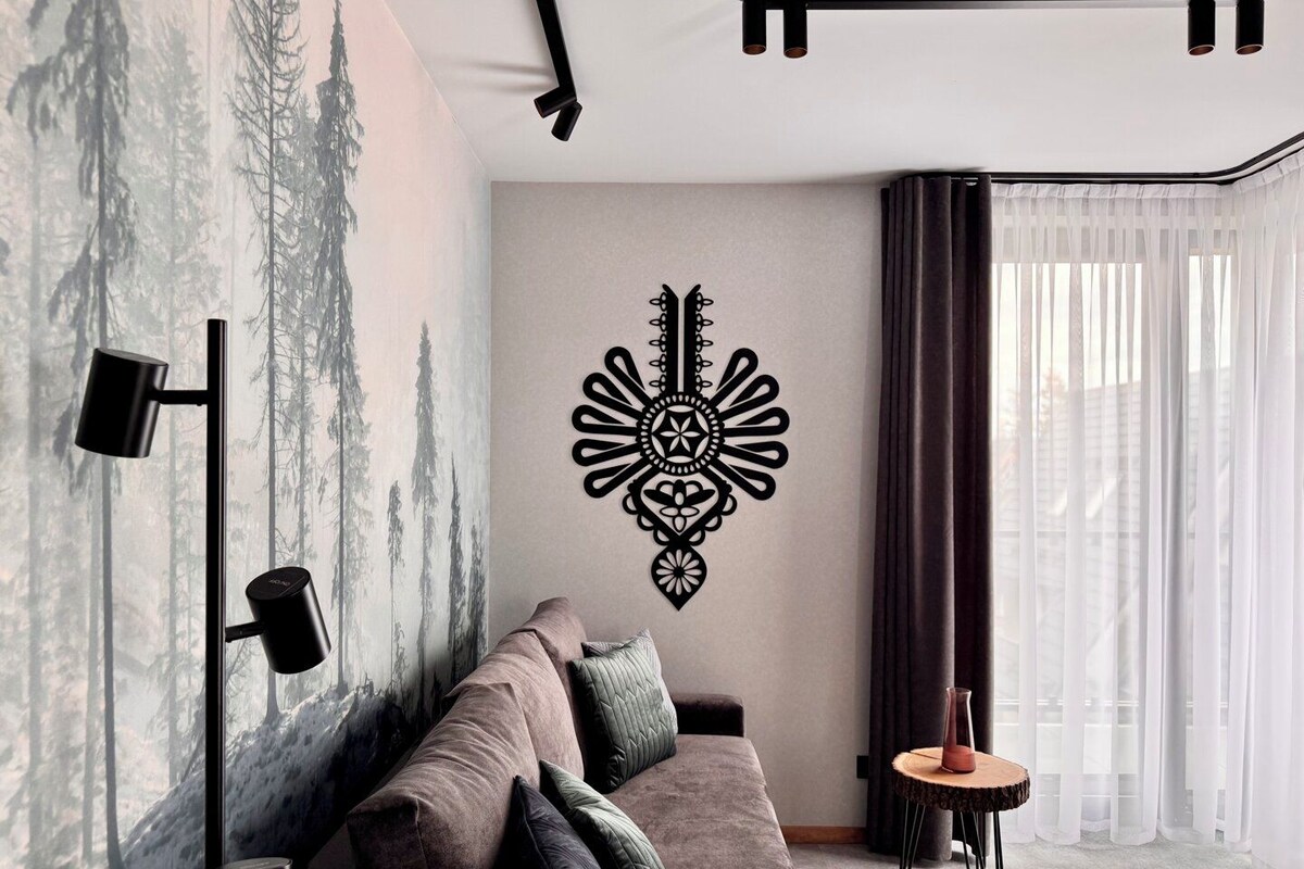 A modern living room with a sofa, a wall-mounted decorative piece, a floor lamp, and a small side table.