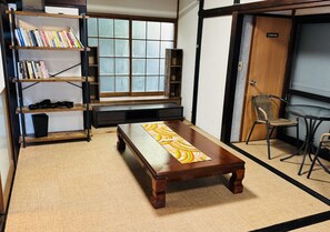 A room with a tatami mat, a wooden coffee table, a bookshelf, and a window. - JapaneseTraditional house ONDa (Zushi)