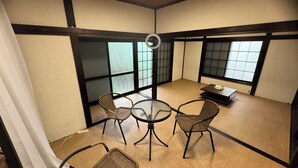 A traditional Japanese room with tatami flooring, a low table with chairs, and sliding shoji doors. - JapaneseTraditional house ONDa (Zushi)