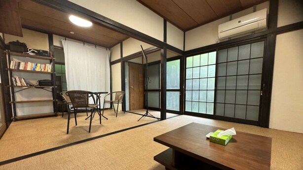 A traditional Japanese-style room with tatami flooring, a low wooden table, a bookshelf, and sliding doors with frosted glass panels. - JapaneseTraditional house ONDa (Zushi)