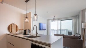 Et moderne køkken med indbygget vinkøler, stort vindue med udsigt og minimalistisk design.