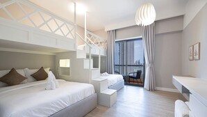A modern hotel room with a large bed, a desk, a balcony with a view of the city, and a hanging light fixture. - World Class | 1BR | Breathtaking Beach Views (JBR, Dubai)