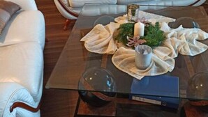 A living room with a glass coffee table, two white leather sofas, and a decorative centerpiece. - Fillner 2 Modern Retreat (Scharbeutz)