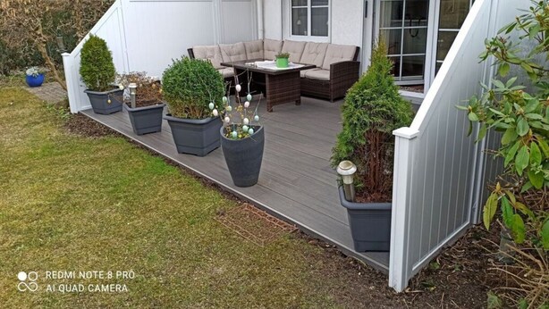 A deck with outdoor furniture, potted plants, and a white fence. - Fillner 2 Modern Retreat (Scharbeutz)
