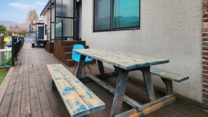 An outdoor patio with wooden benches and a blue chair. - Gapyeong Ttonggangaji Kids Poolvilla (Gapyeong)