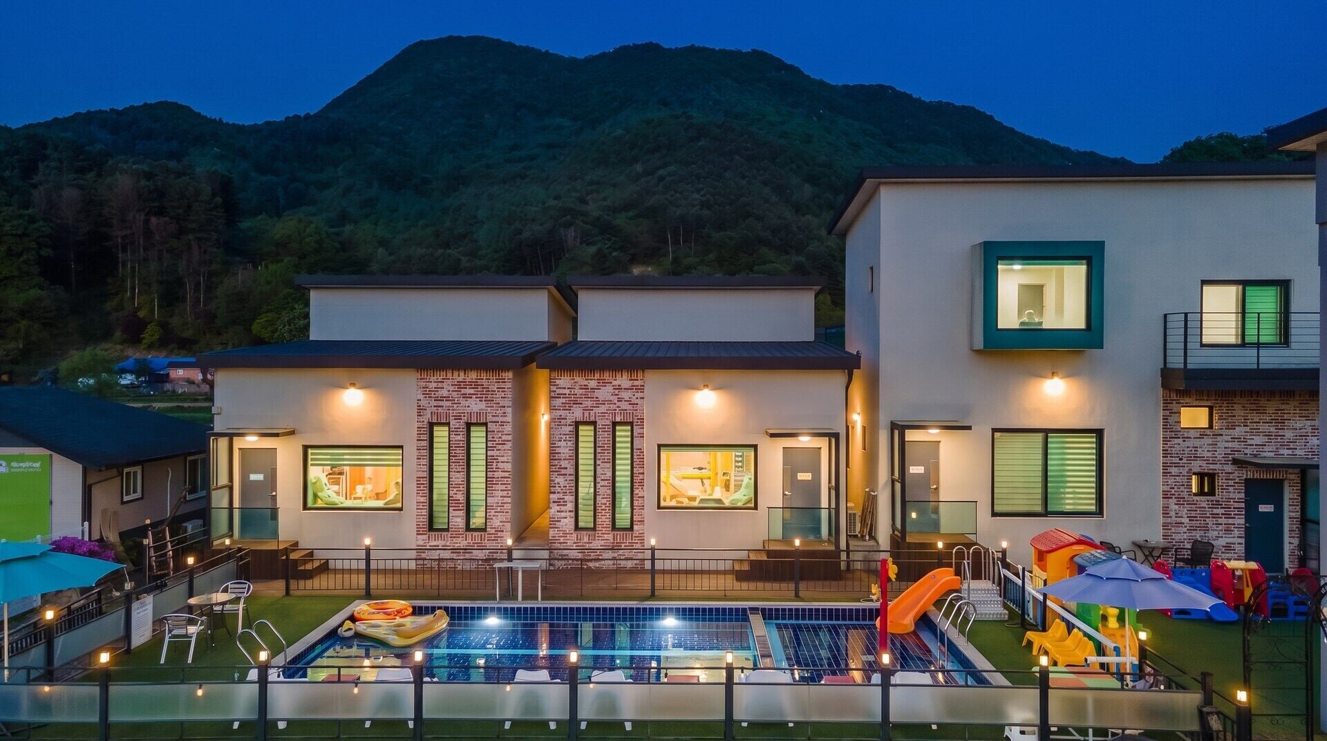A modern building with a swimming pool and outdoor seating.