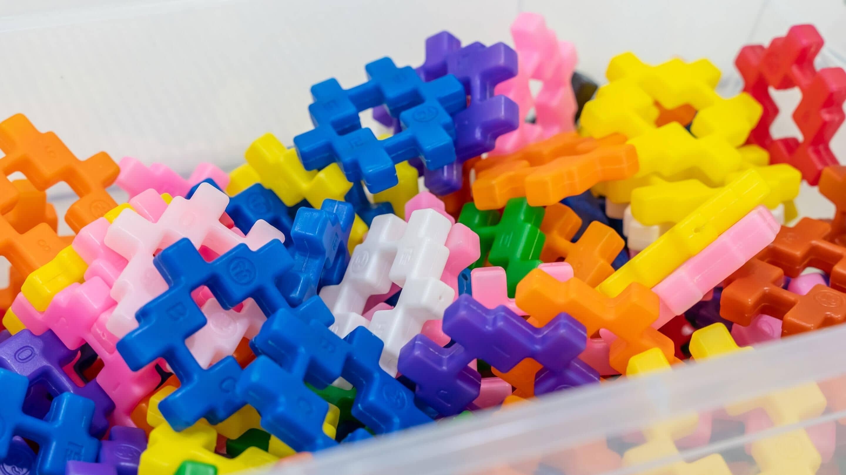 A container filled with colorful plastic building blocks.