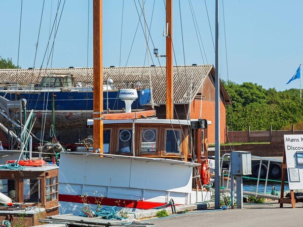 A docked boat with a cabin and a signboard in the background.