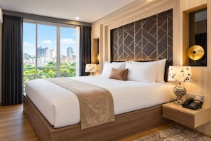 A hotel room with a large bed, two bedside tables with lamps, a view of the city through large windows, and a modern headboard. - Aspira Suites Sukhumvit 20 (Bangkok)