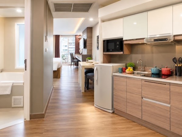A modern kitchen with wooden cabinets, a microwave, and a refrigerator.