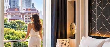 A hotel room with a bed, a view of the city, and a balcony.