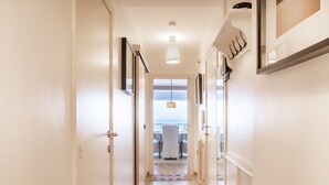 A narrow hallway with wooden flooring leading to a balcony with a view. - Apartment in Ostend With Stunning Sea View (Koksijde)