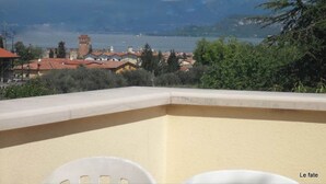 Una terraza con vistas a un lago, edificios y una torre.