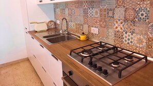 A kitchen with a gas stove, a sink, and a countertop. - Olive Grove Garden House With Mountain View Close to Forte dei Marmi (Ripa- Pozzi-Ponterosso)