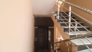 Una escalera con barandillas metálicas que conduce a una puerta oscura.