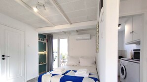 Een moderne slaapkamer met een groot bed, een ingebouwde wasmachine en uitzicht.