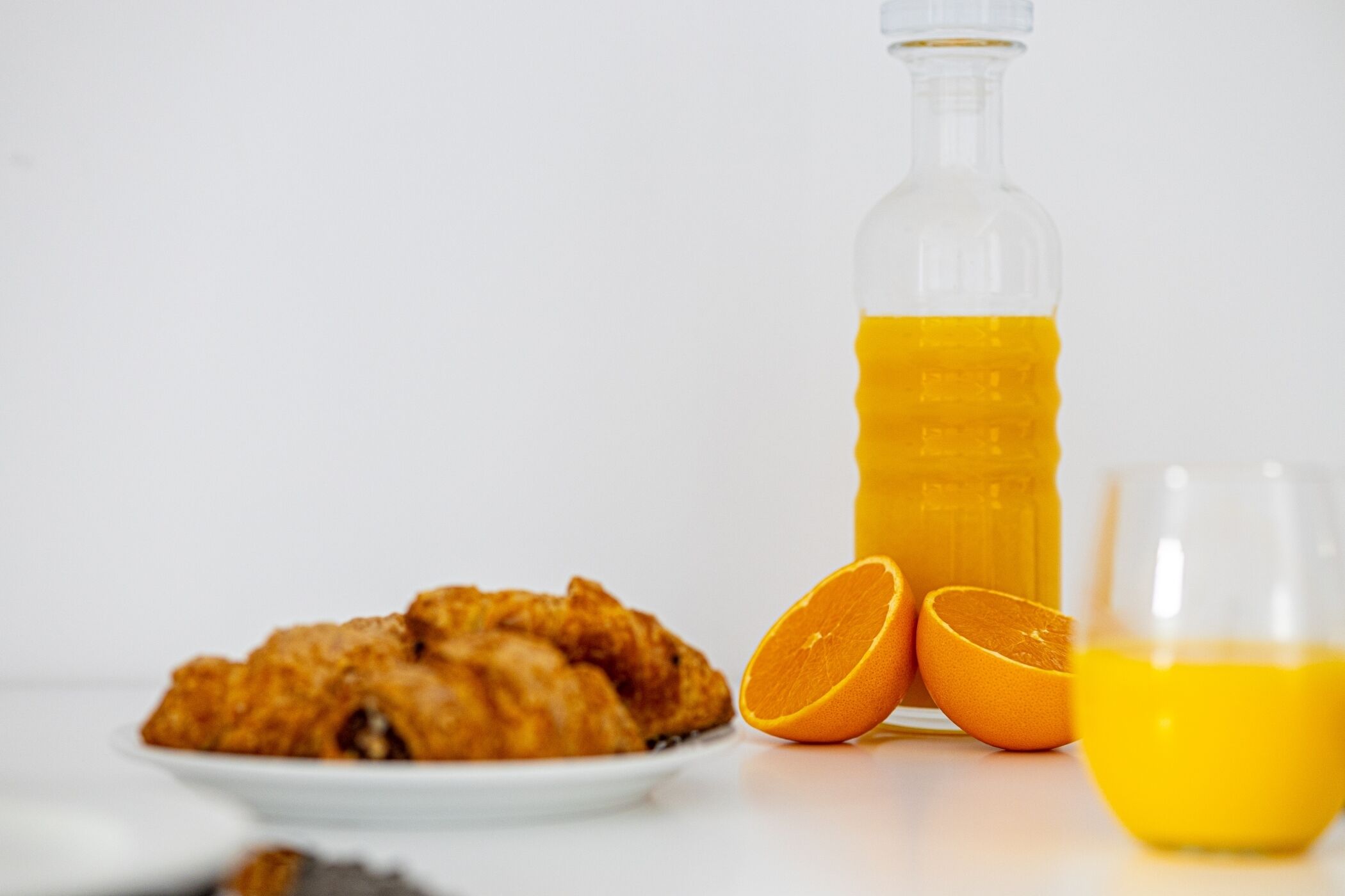 A plate of fried chicken, a glass of orange juice, and a bottle of orange juice.
