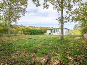 Une maison moderne avec une grande pelouse et des arbres.