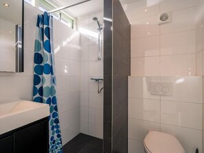 Une salle de bain moderne équipée d’une douche, de toilettes et d’un lavabo.