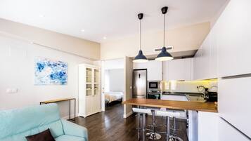 A modern apartment with a kitchen, dining area, and living room.