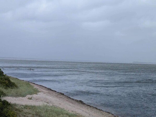 A coastal view with a sandy beach and calm sea.