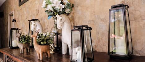 A wooden table with decorative items including a white horse sculpture, a deer sculpture, and two lanterns.