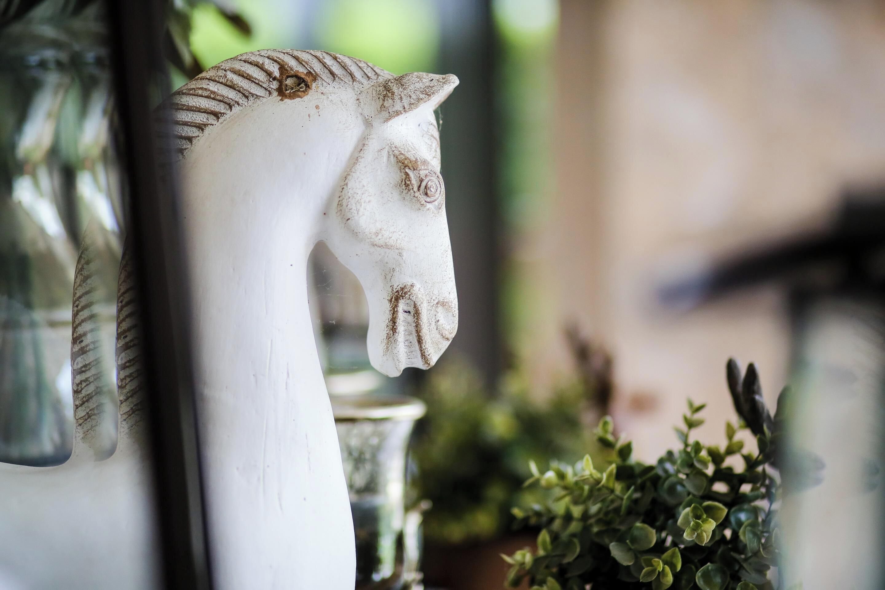A white horse head sculpture on a wall.
