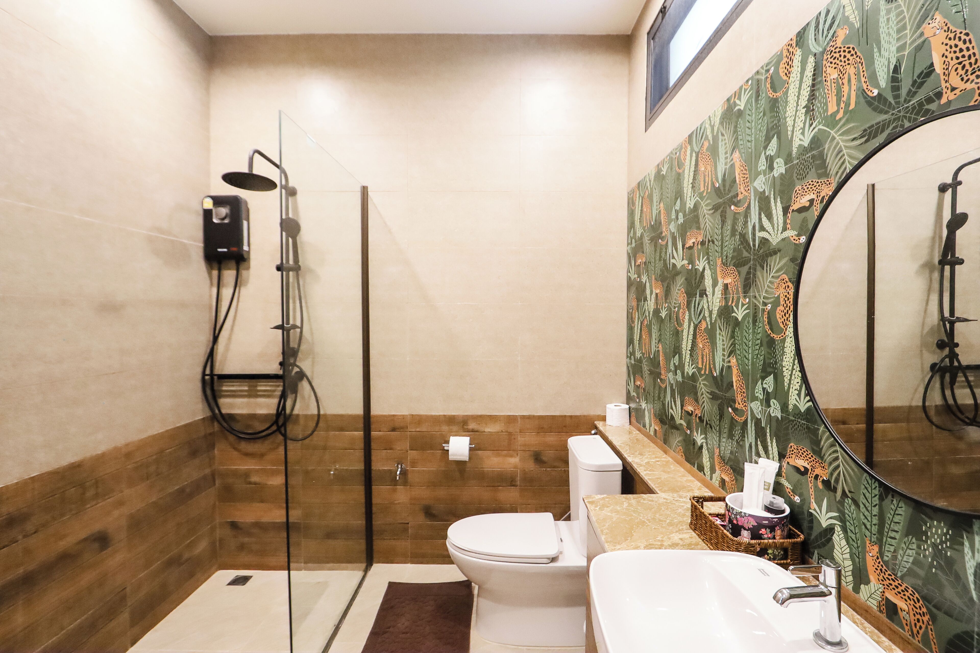 A bathroom with a glass-enclosed shower, a toilet, and a sink with a mirror.