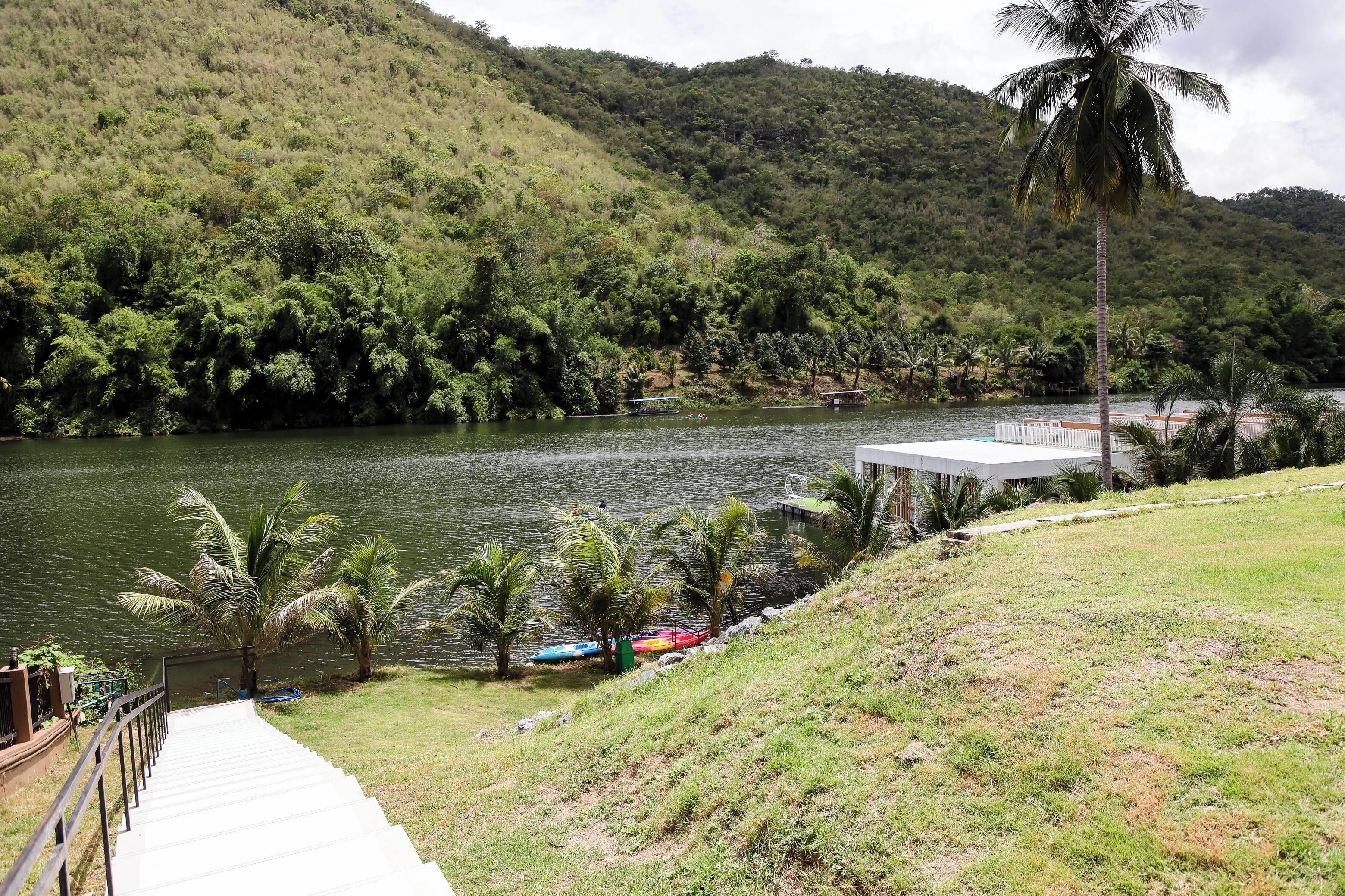A pathway leading to a building with a view of a lake and hills.