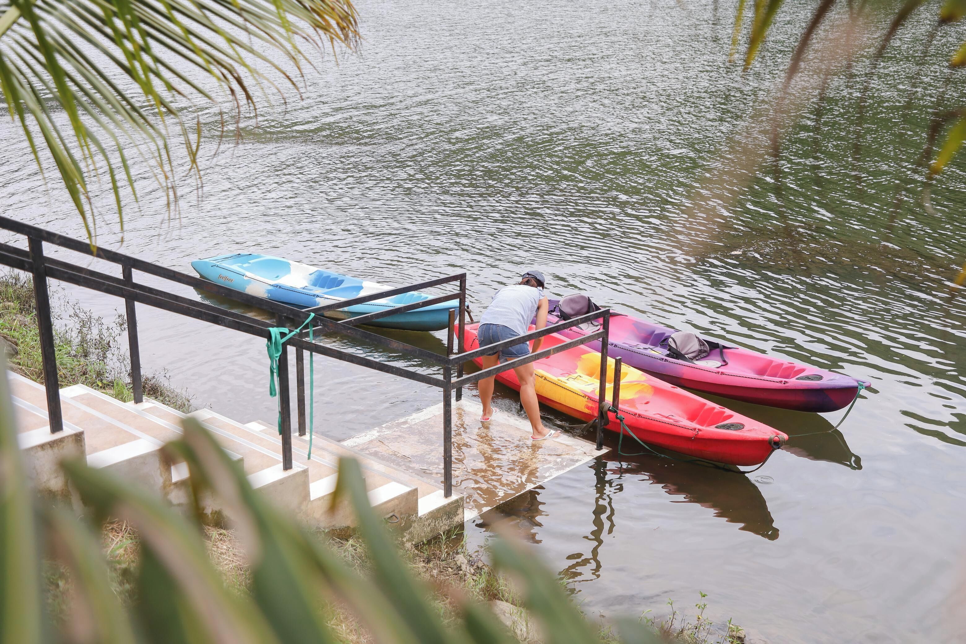 A dock with kayaks and a person preparing to board.