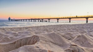A beach with a pier extending into the water. - Appartementhaus Haus Strandperle (Zinnowitz)
