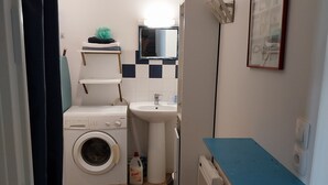 A compact kitchen with a washing machine, sink, and a small countertop. - Apartement de 1 à 4personnes 200m de la mer (La Turballe)