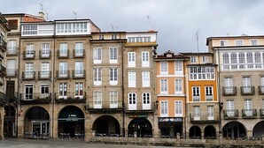 Una fila di edifici a più piani con negozi e attività commerciali al piano terra, tra cui un ristorante e un hotel.