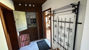 A hallway with a radiator, a door leading to a room, and a tiled floor. - Cosy Apartment in Gortipohl With Garden (Sankt Gallenkirch)