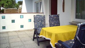 A patio with two chairs and a table covered with a yellow tablecloth. - to the Beach Comfortable Holiday Residence (Lubmin)