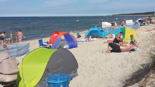 A beach with multiple tents and beach chairs. - to the Beach Comfortable Holiday Residence (Lubmin)