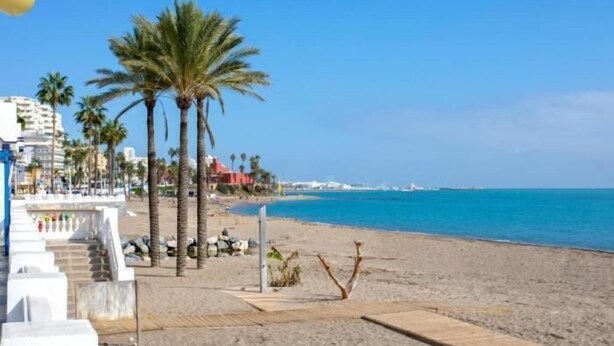 A beach with palm trees, a wooden boardwalk, and a clear blue sky. - Sunstay Portview Marina Flat II Benalmadena (Benalmádena)