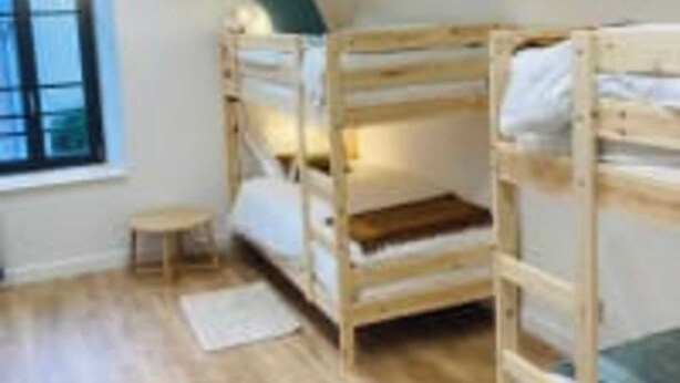 A room with three bunk beds, a small table, and a window. - Le Domaine des Figuiers - Le Gîte des Pèlerins (Servon)