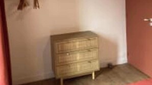A room with a wooden dresser, a door, and a wall-mounted shelf. - Le Domaine des Figuiers - Le Gîte des Pèlerins (Servon)