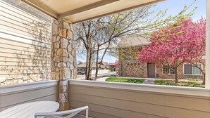 A covered outdoor seating area with a stone pillar, a table, and chairs. - Beacon at the Lakes - Cozy & Bright 2bd/2ba Ground Level Condo (Windsor)