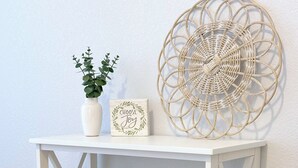 A white bookshelf with books, a small plant, a decorative wall piece, and a sign saying "Choose Joy". - Beacon at the Lakes - Cozy & Bright 2bd/2ba Ground Level Condo (Windsor)