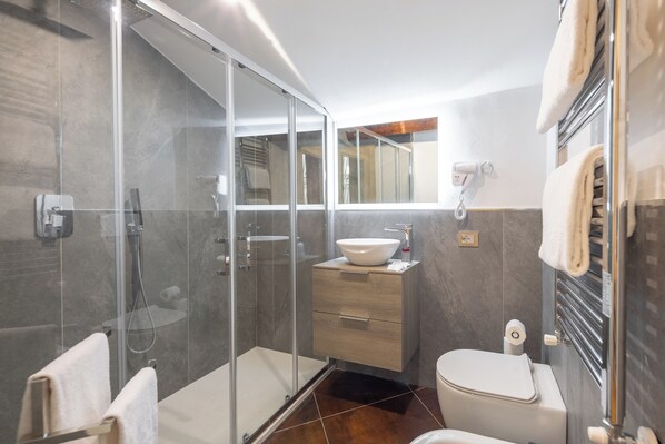 A modern bathroom with a glass shower enclosure, a white sink, and a toilet. - Palazzina Fusi (Florence)