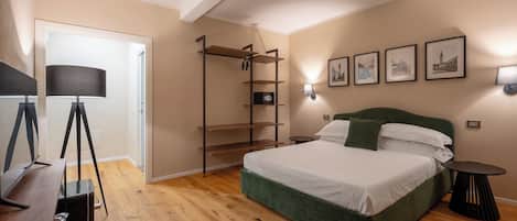 Un dormitorio con cama, escritorio, lámpara, estantería e iluminación en la pared.
