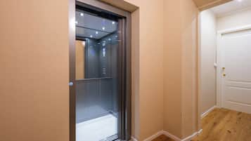 An elevator with a metallic finish and a control panel.