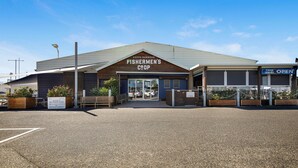 A building with a sign reading "Fishermen's Coop" at Coff's Harbour. - Ocean Spray 8 - 2BR Perfect Coastal Retreat in Vibrant Coffs Harbour (Coffs Harbour)