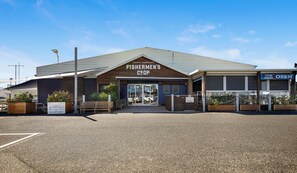 A building with a sign reading 'Fishermen's Coop' and a 'Take Away Open' sign.