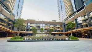 A modern building with multiple floors, large windows, and a central courtyard with a fountain and trees. - The Opera Residence Bitexco view (Ho Chi Minh City)